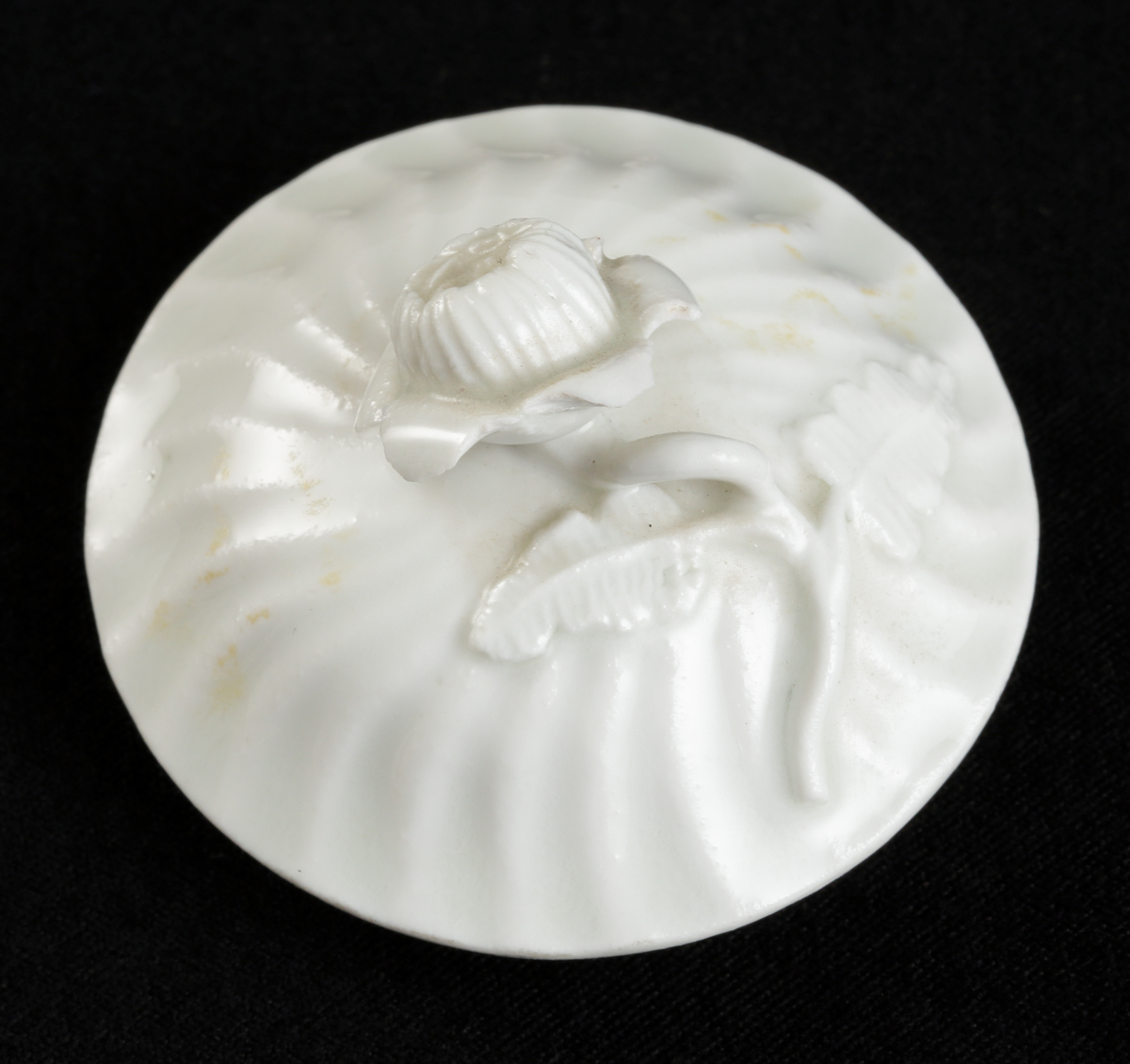 Krämkopp med lock, av porslin. Vitglaserad.
Något bukig modell, vridna räfflor å lock och knopp. På locket en skulpterad blomma som knopp.

Inskrivet i huvudbok 1967.