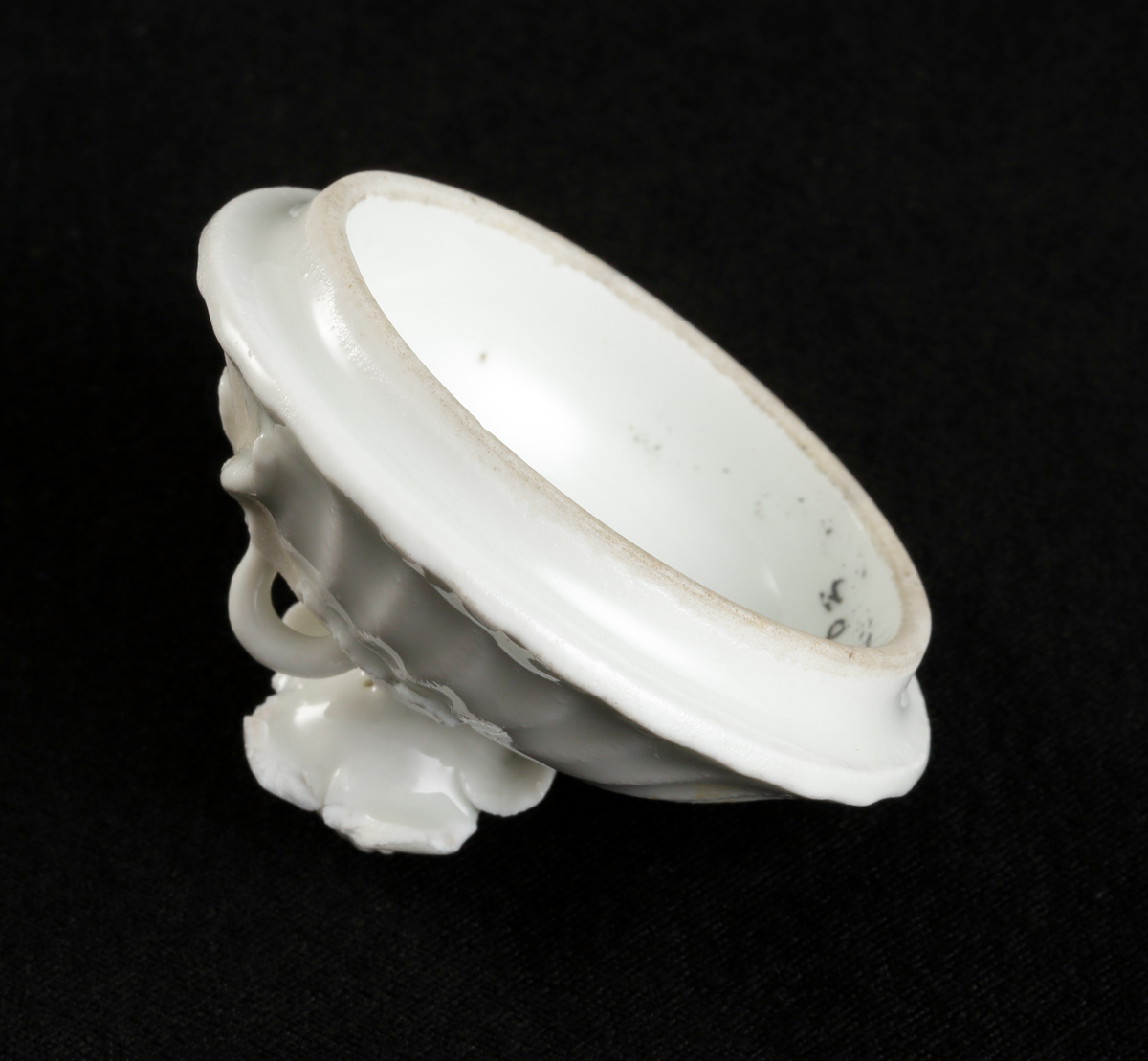 Krämkopp med lock, av porslin. Vitglaserad.
Något bukig modell, vridna räfflor å lock och knopp. På locket en skulpterad blomma som knopp.

Inskrivet i huvudbok 1967.