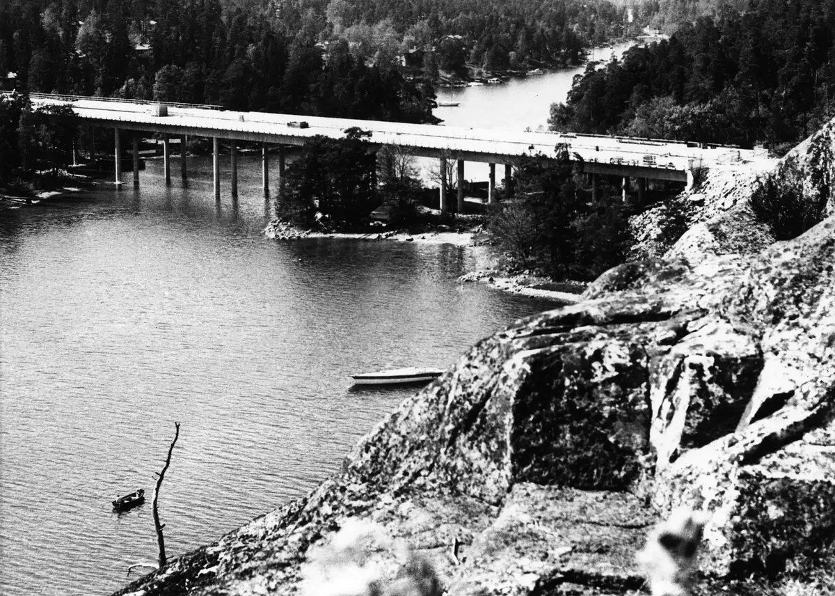 Bron över Kihlsviken sedd från Ekoberget. På udden vid det hitre brofästet låg tidigare Kihls fiskeläge. Fiskestugan skymtar mellan bropelarna. I strandkanten därbortom ses resterna av Eriksviks gård.