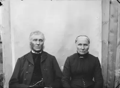 Personane på biletet er Ola Olson Mølmen (1830–1912) og Kari Hansdotter Mølmen (1835–1917) frå Søre Sør-Einbu. Ola og Kari åtte i ein periode fleire gardar på Lesjaskog. Dei overtok Mølmen i 1856, kjøpte seinare Nørdre Sy Kvam og Søre Sy Kvam. Ein periode åtte dei òg Ner-Enstad og Vesl-Enstad. På Mølmen var det både skysstasjon, landhandel, postopneri og sagbruk. Skyssverksemda vart det slutt på då jarnbanen opna.