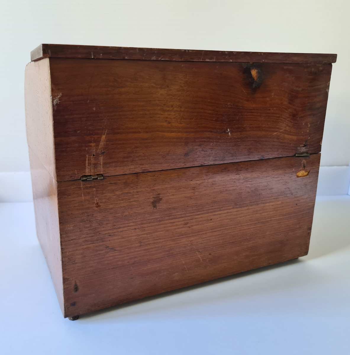 Reiseskrin med seks karafler og to glass. Skrinet er utformet i lys mahogny. Plass innvendig til seks karafler med propp, og to små stettglass. Skrinet er inndelt i seks seksjoner og trukket med mørk blå fløyel nede i rommene og (blass) rød fløyel oppe ved kantene og under lokket. I lokket er det også et spor til å feste to glass. Disse er det ikke plass til når skrinet lukkes. Hengslet lokk. Nøkkelhull foran. Nøkkel mangler.