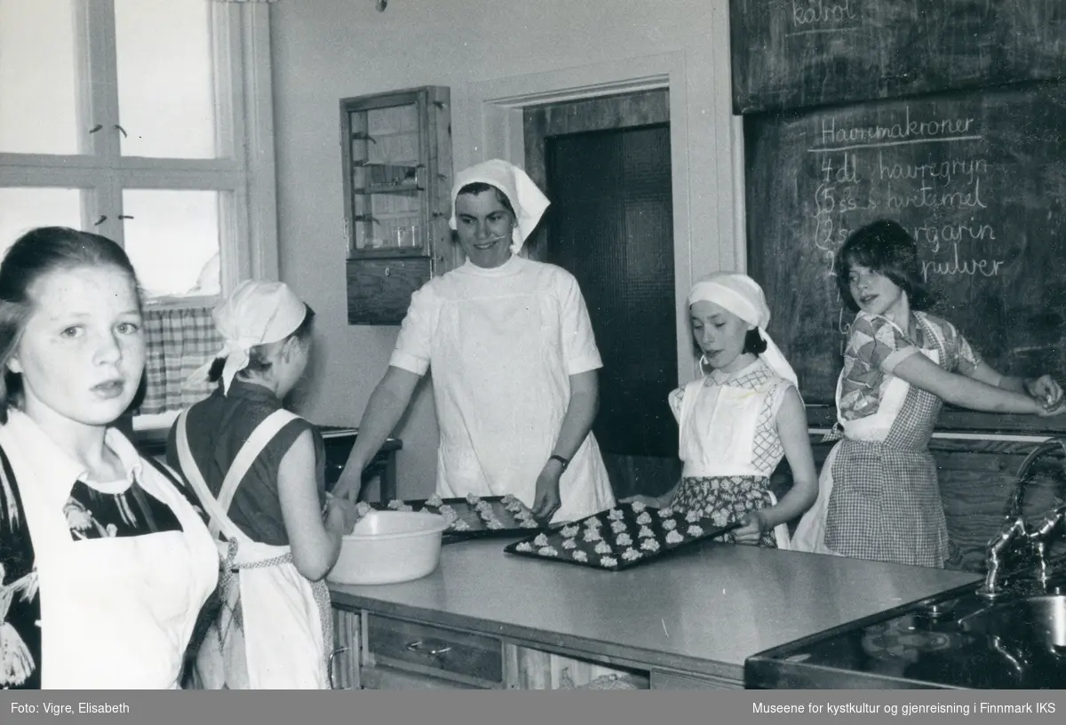 Solvang internatet på Sarnes. Skolekjøkken. Noen av jentene og lærerinne Elisabeth Bertelsen (g. Vigre) baker havremakroner. 1960/61.