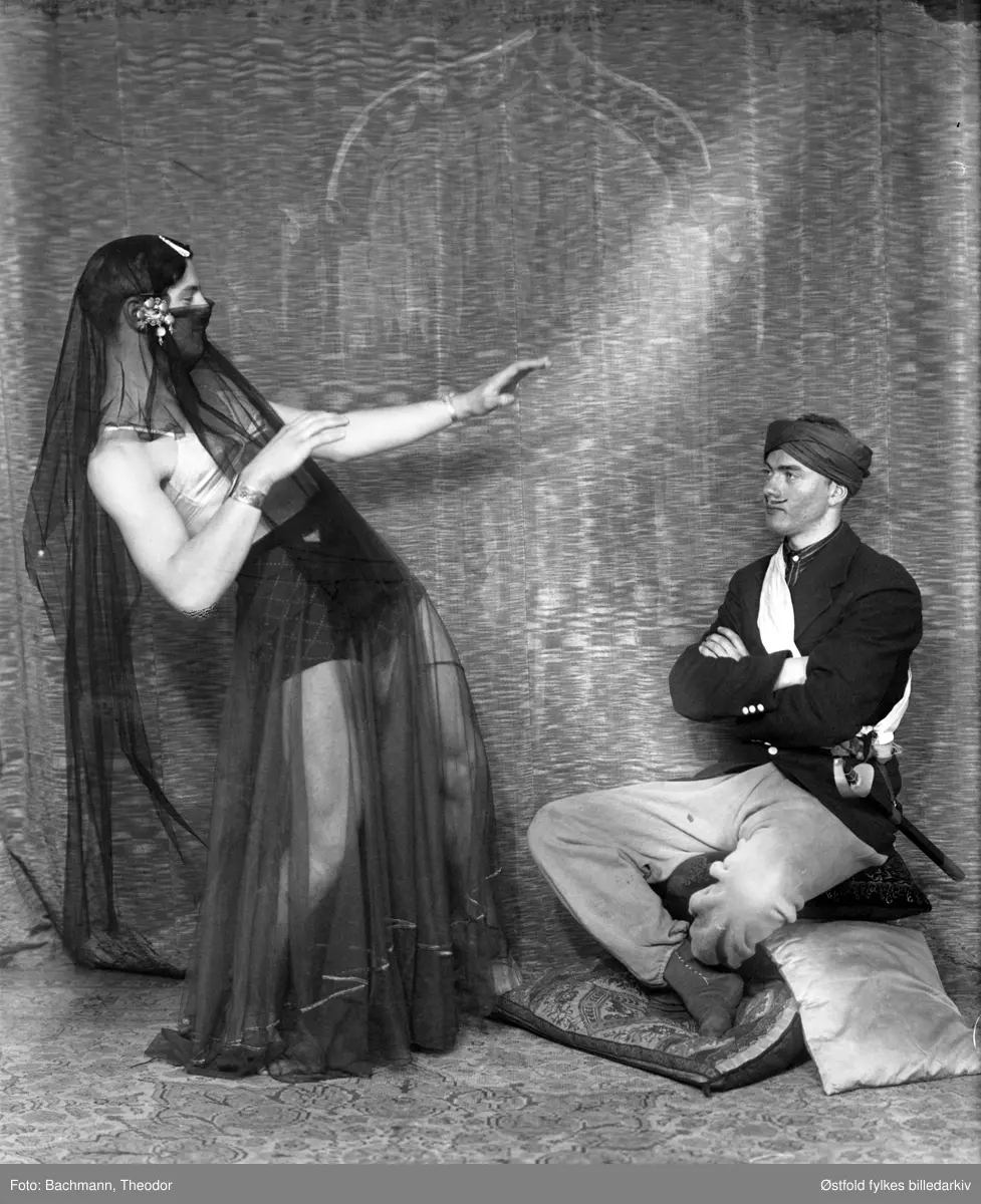 Scenebilder fra Livbåtens Ungdomsforening i Moss sin revy "Det Bølger" som hadde premiere i Moss Hotells teatersal 26. april 1941. Til inntekt for redningsselskapet. Iscensatt av Ole S. Dolva. I Moss Avis 25.04.1941 blir det beskrevet i annonsen at "Se fotoreportasjen i Moss Hotells plakatkasse". Det må være denne fotoserien til fotograf Bachmann som var utstilt.