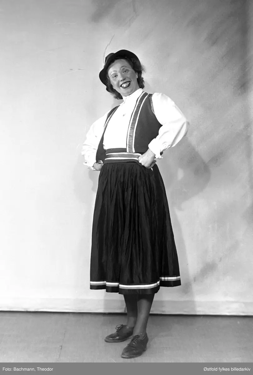 Scenebilder fra Livbåtens Ungdomsforening i Moss sin revy "Det Bølger" som hadde premiere i Moss Hotells teatersal 26. april 1941. Til inntekt for redningsselskapet. Iscensatt av Ole S. Dolva. I Moss Avis 25.04.1941 blir det beskrevet i annonsen at "Se fotoreportasjen i Moss Hotells plakatkasse". Det må være denne fotoserien til fotograf Bachmann som var utstilt.
