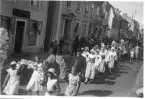 Kortege på Brahegatan i Gränna med barn och vuxna i folkdräkt - Vistadräkten. Det är hembygdsfest.