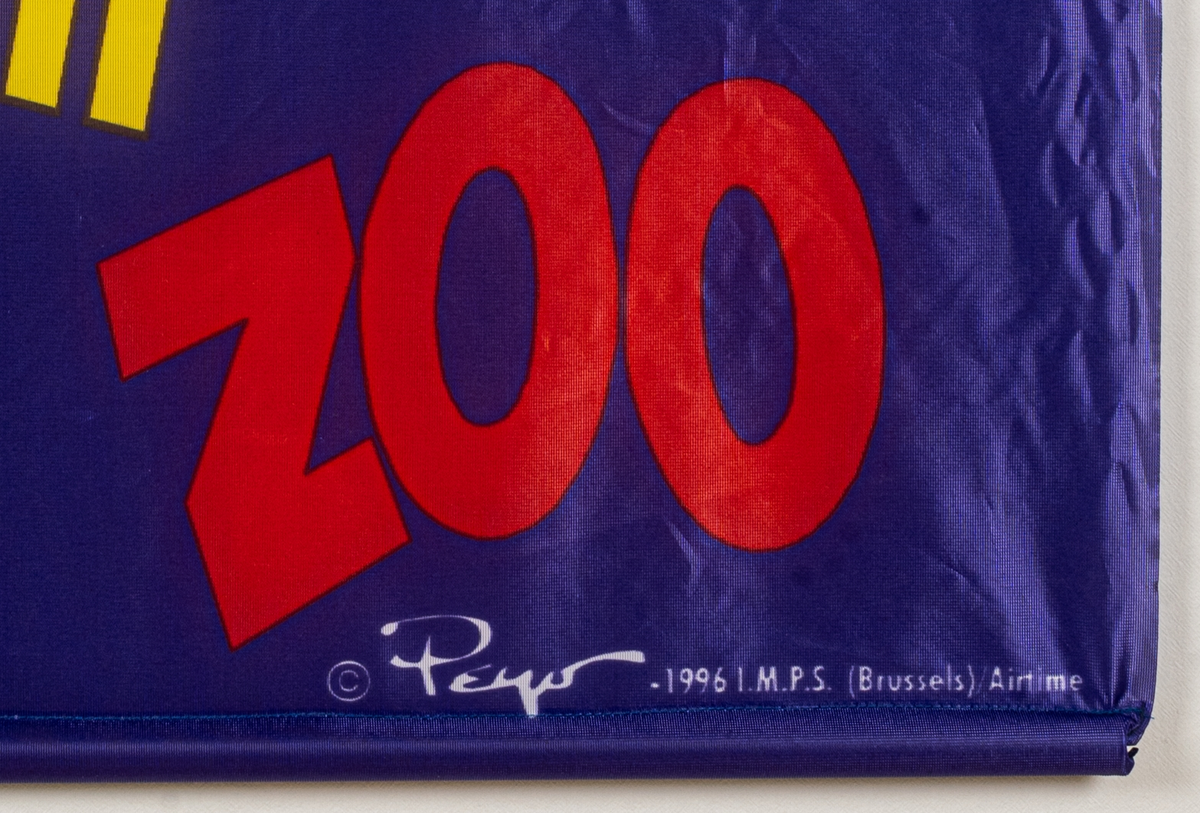 Reklamföremål, tygbanderoll i lila med dekor av tecknade smurfar samt produkttitlarna Zoo, PimPim SMURF, Fruxo och Skurt.