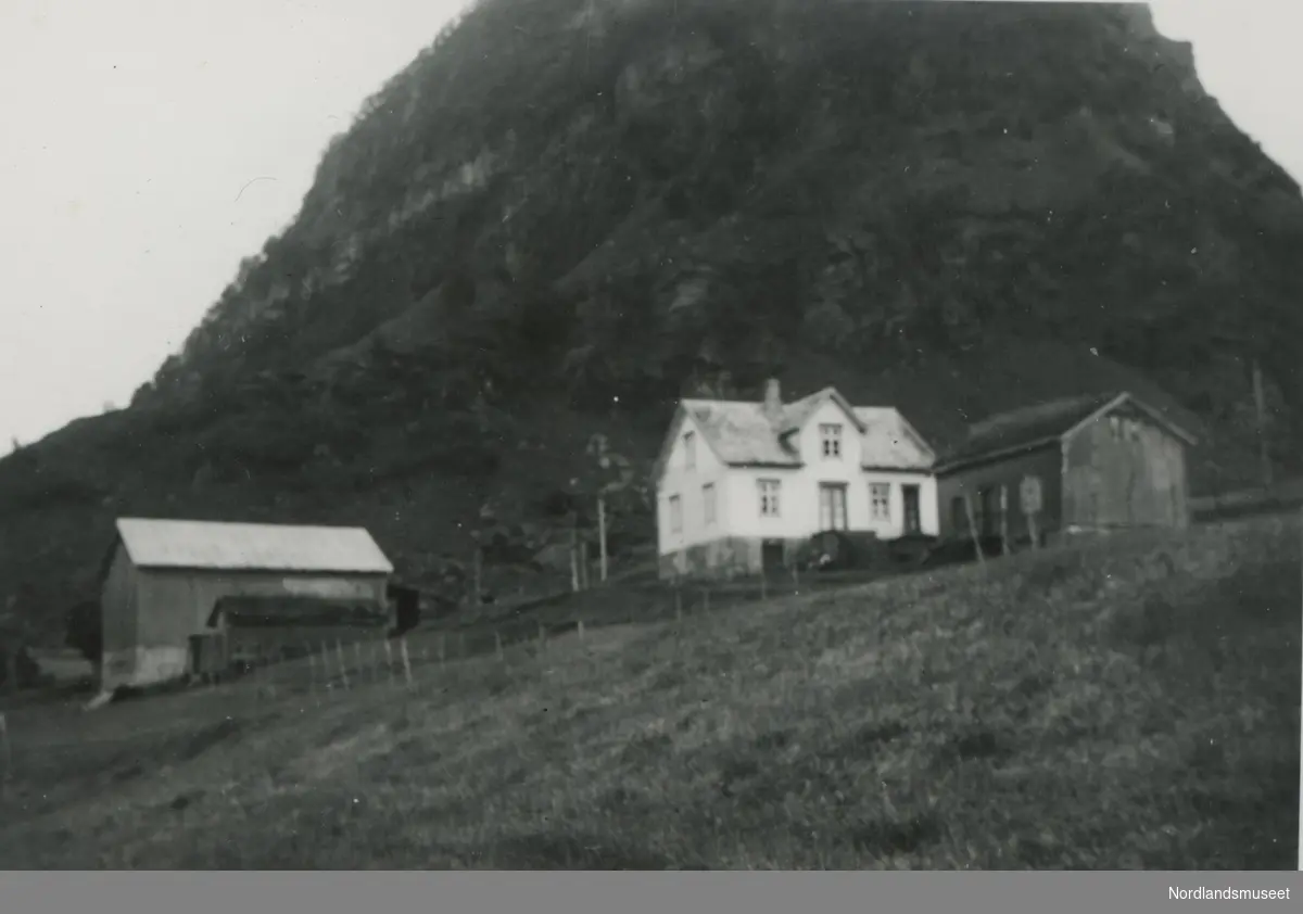 Gård med bolighus og fjøs. Gården Mjelde på Engeløya i Steigen. Gnr. 90, bnr. 3. I bakgrunnen er fjellet Jarstakktinden.