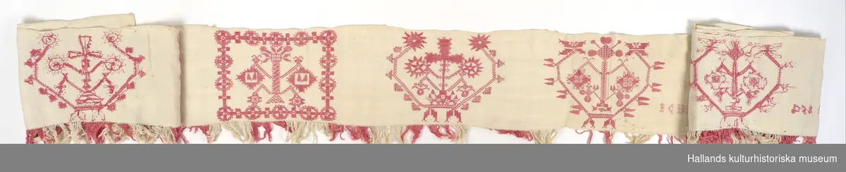 Hängkläde av vit linnelärft. Rikt broderad i hela sin längd med hallandsmönster av rödfärgat bomullsgarn. Sammanlagt 13 broderade mönsterpartier, varav samtliga mönster unika. I hängklädets mitt finns en broderad märkning: "ICBD 1854".

Nedtill längs hängklädets hela längd en list av påsydda fransar i omväxlande rött- och vitfärgat bomullsgarn.