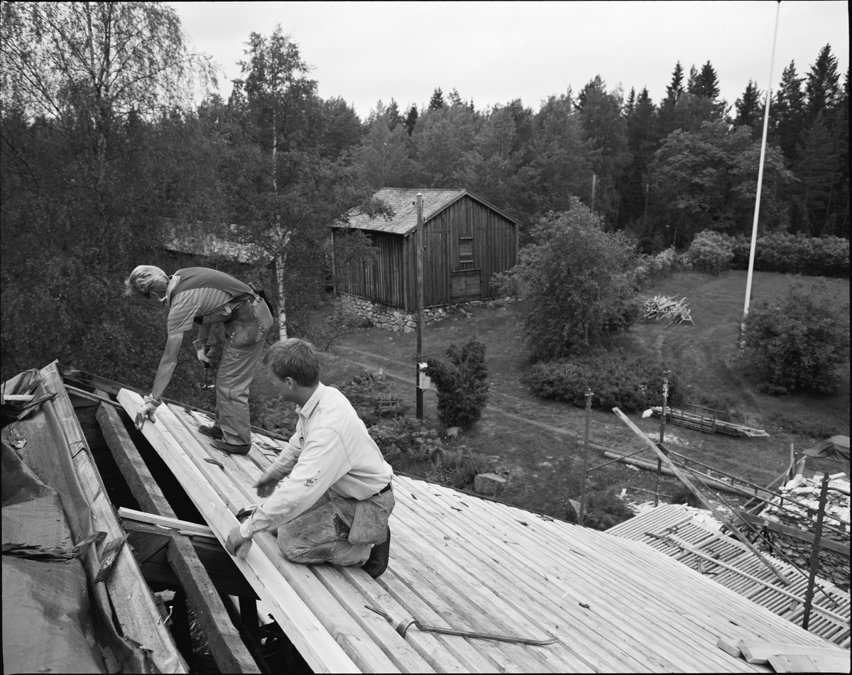 Ösjöfors, bruksbyggnad. Omläggning av spåntak. Lägger takpanel på brukets norra sida.