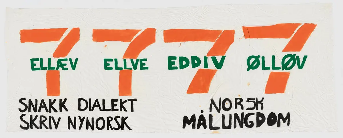 Banner frå arkivet til Norsk Målungdom. På banneret vert logoen til selskapet 7 - eleven omskrive til dialekt. Teksten er: "7 - ellev 7 - ellve 7 - eddiv 7 - ølløv. Snakk dialekt - skriv nynorsk! Norsk Målungdom". Det er truleg at banneret har vore i bruk under ein dialektaksjon for Norsk Målungdom.