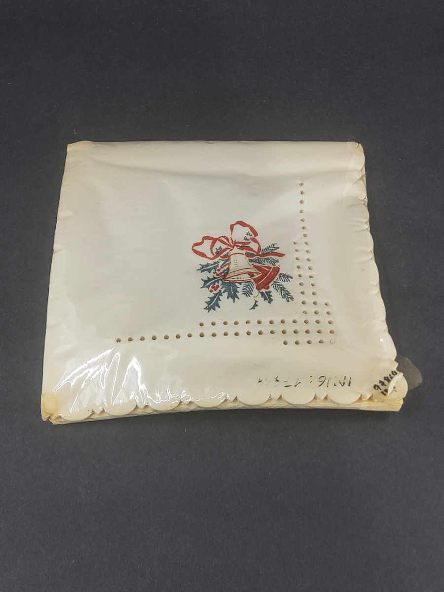 Förpackning med servetter. Plastomslag med pappersservetter, dekorerade genom vågig kant, perforeringar och tryckt julmotiv med klockor.
Se inv. nr 97821.

Enl liggare "Från Clarence Janssons handel i Ö. Sörby, Borgholm, som drevs 1933-1971"

Neg.nr: 1986-07