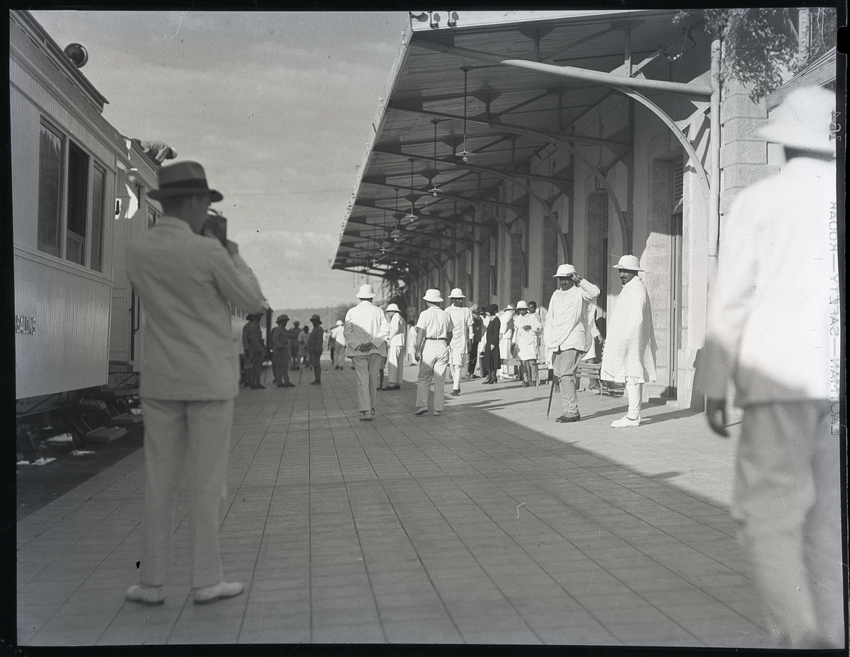 Foto tatt togstasjon på reise i Afrika, muligens i nærheten av keisseriket Etiopia (dagens  Etiopia og Eritrea)

Keiserriket ble også kalt Abessinia 

En mann med kamera står helt til venstre

Negativet lå i konvolutt med pårskrift: Abesinier