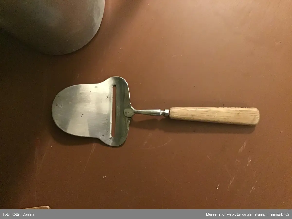 Bladet til ostehøvelen er av metall og har en glatt skjærekant. Tuppen er halvrund. Formen tilsvarer dagens form av høvler som er tiltenkt kjæring av brunost. Håndtaket er av tre.