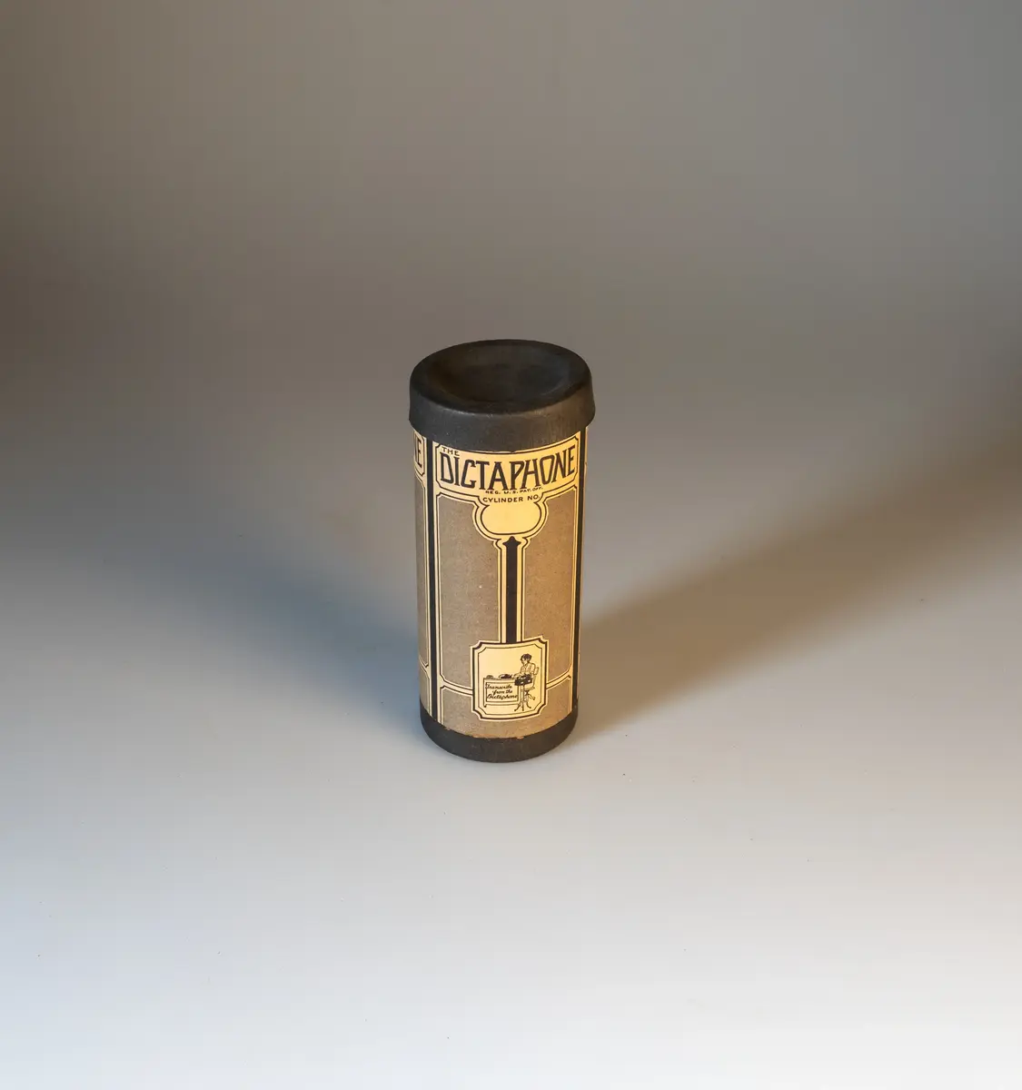 Parlograf med 3 tillhörande rullar. Apparaten består av en svart låda med handtag på sidorna av metall. Märkt framtill med "Parlograph" i guld. Välvt, löstagbart lock med handtag upptill. Vid reglagen märkt "CARL LINDSTRÖMS PARLOGRAPH, svensk uppfinning, Generalagent: AKTIEBOLAGET ERKI, Stockholm".