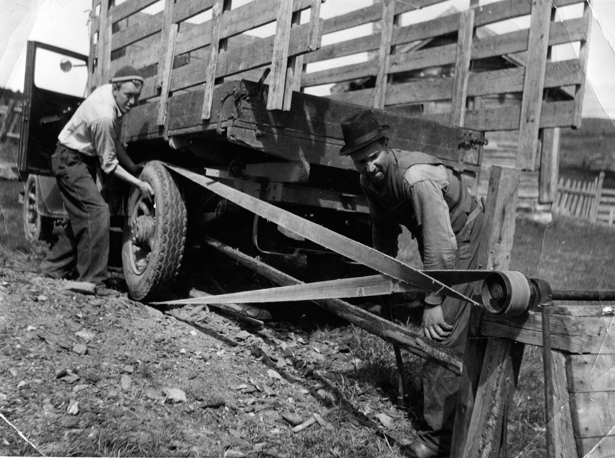 Vedkapping på Kamben 1950, lastebil blir brukt som drivkraft for vedkappen. Frå h. Ola Treverket og Steingrim Haugen
