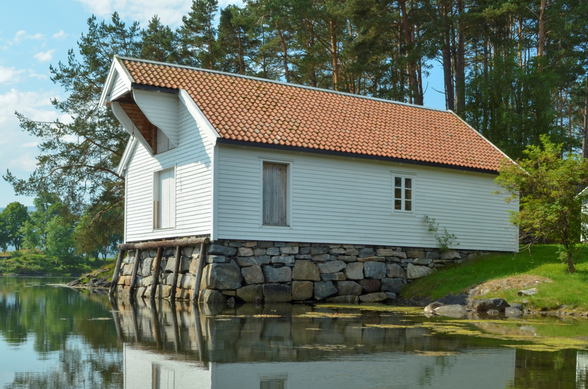 Kvitmala med teglstein. Vindehus og vindedører mot aust. Inngang og krambu mot vest. Sulagt enkeltfalsa bordkledning.