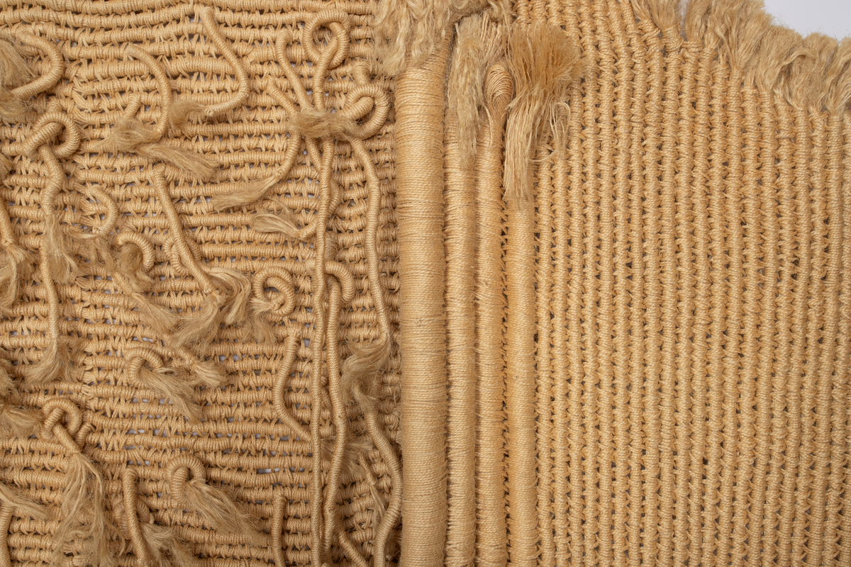 Billedvev av naturfarget sisal. Bunter av omviklede renningstråder er delvis sammenvevd til flater, delvis festet til flaten som lange pølser og løsthengende haler. Tekstilet er vevd i tre deler med et rektangulært midtfelt mellom to tilnærmet rektangulære sidefelt. Sidefeltene er glatte, mens midtfeltet fremstår frodig med lange og korte nedhengende duskehaler, de lengste så lange at de kryper ned fra veggen og utover gulvet.