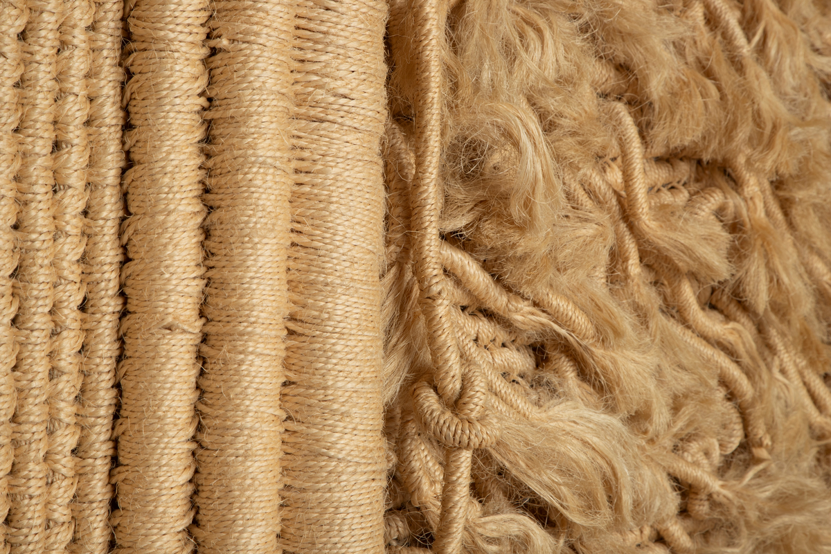 Billedvev av naturfarget sisal. Bunter av omviklede renningstråder er delvis sammenvevd til flater, delvis festet til flaten som lange pølser og løsthengende haler. Tekstilet er vevd i tre deler med et rektangulært midtfelt mellom to tilnærmet rektangulære sidefelt. Sidefeltene er glatte, mens midtfeltet fremstår frodig med lange og korte nedhengende duskehaler, de lengste så lange at de kryper ned fra veggen og utover gulvet.