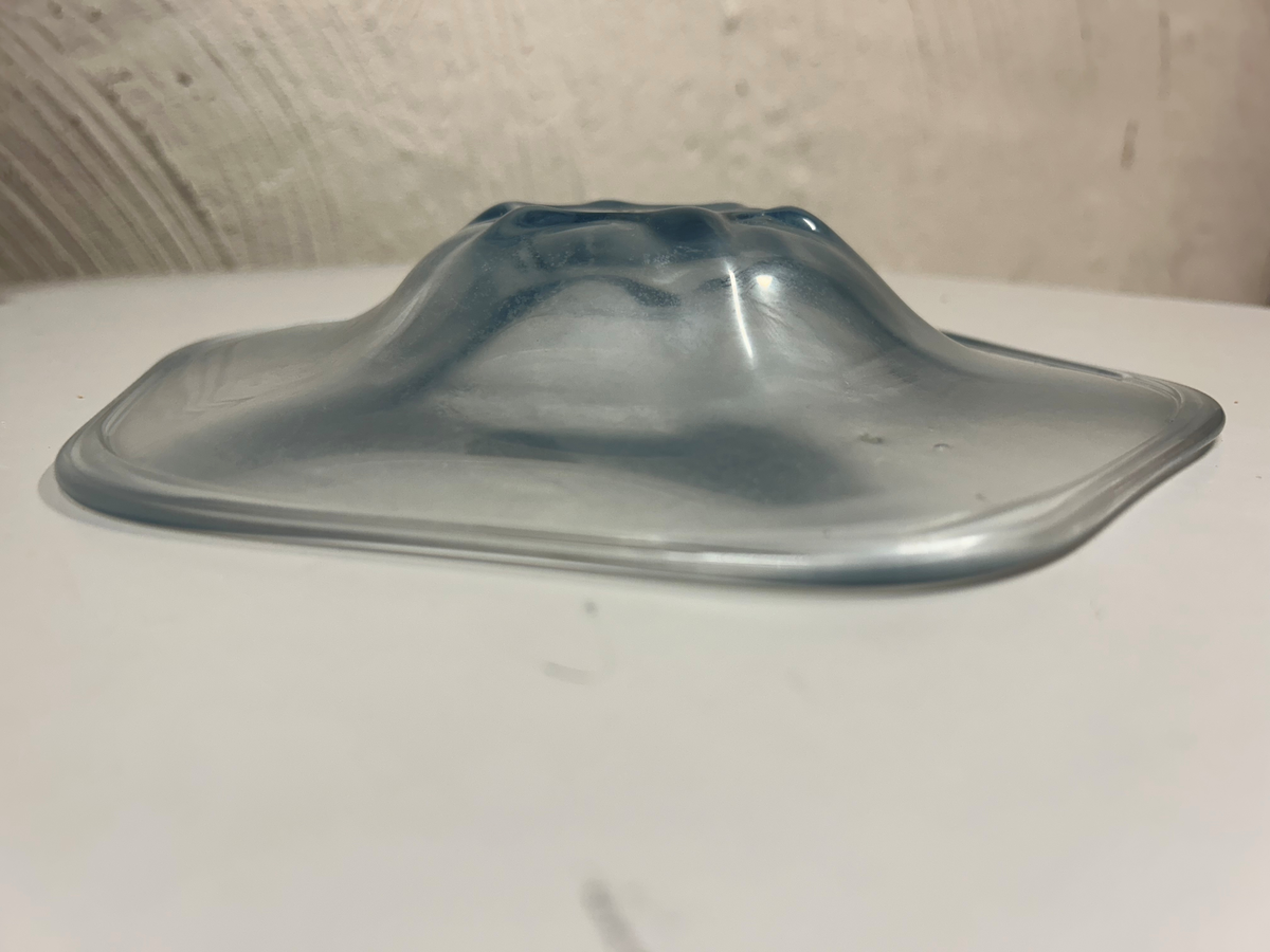 Blåtonat glas, sexkantig med fördjupning i mitten.