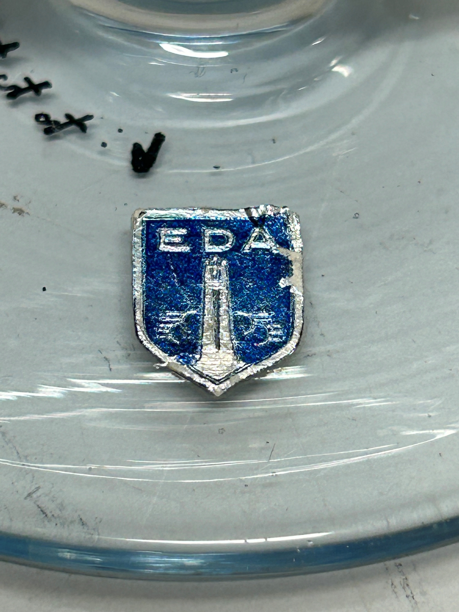 Karaff med propp, av blåtonat glas. Rund fot, flat form, intryckt på mitten, kort hals med utvikt mynningskant, strålformad dekor på ytterkanter och propp.