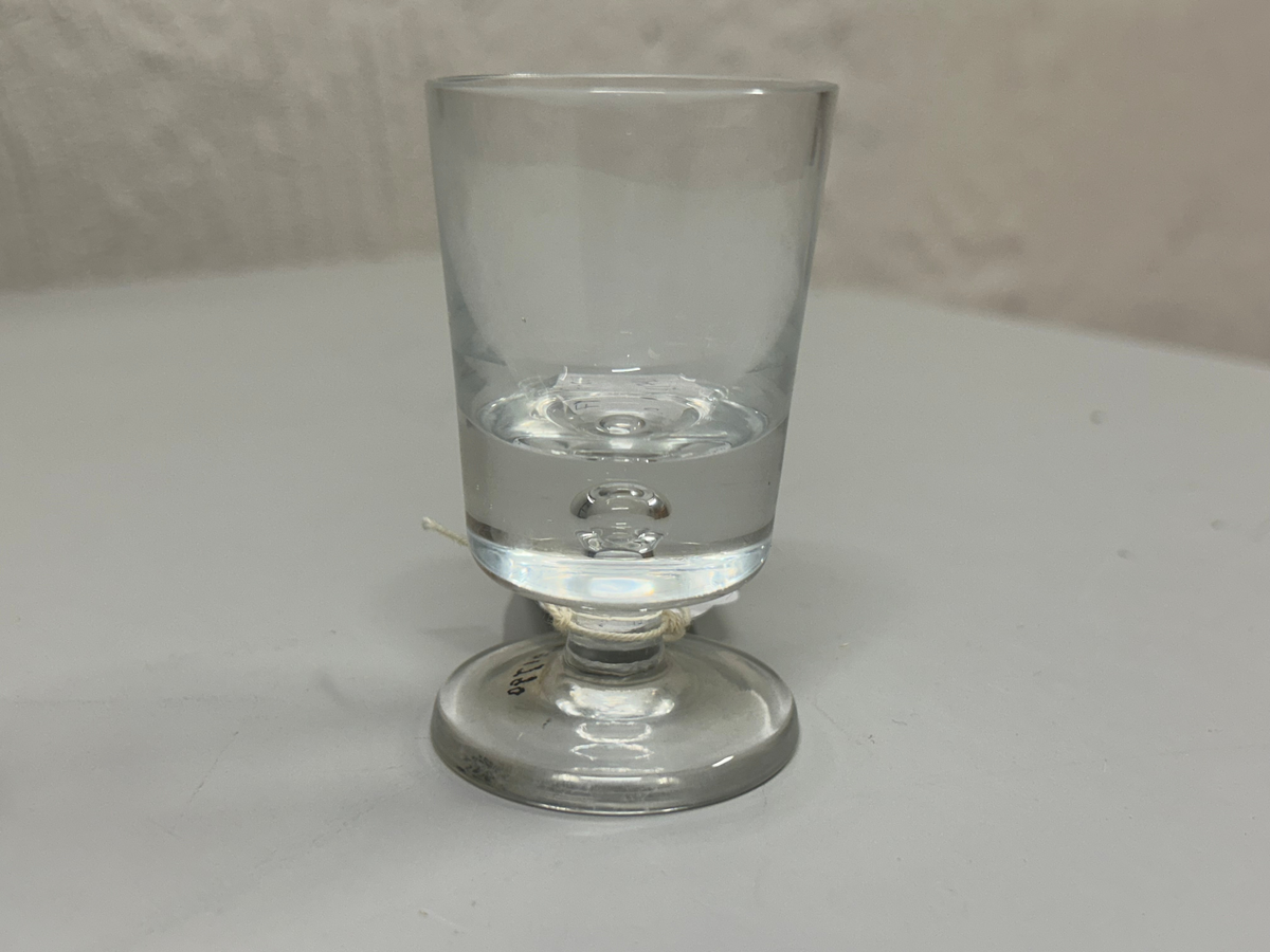 Dricksglas med formen av tjockbottnad, konisk kupa på rund fot.