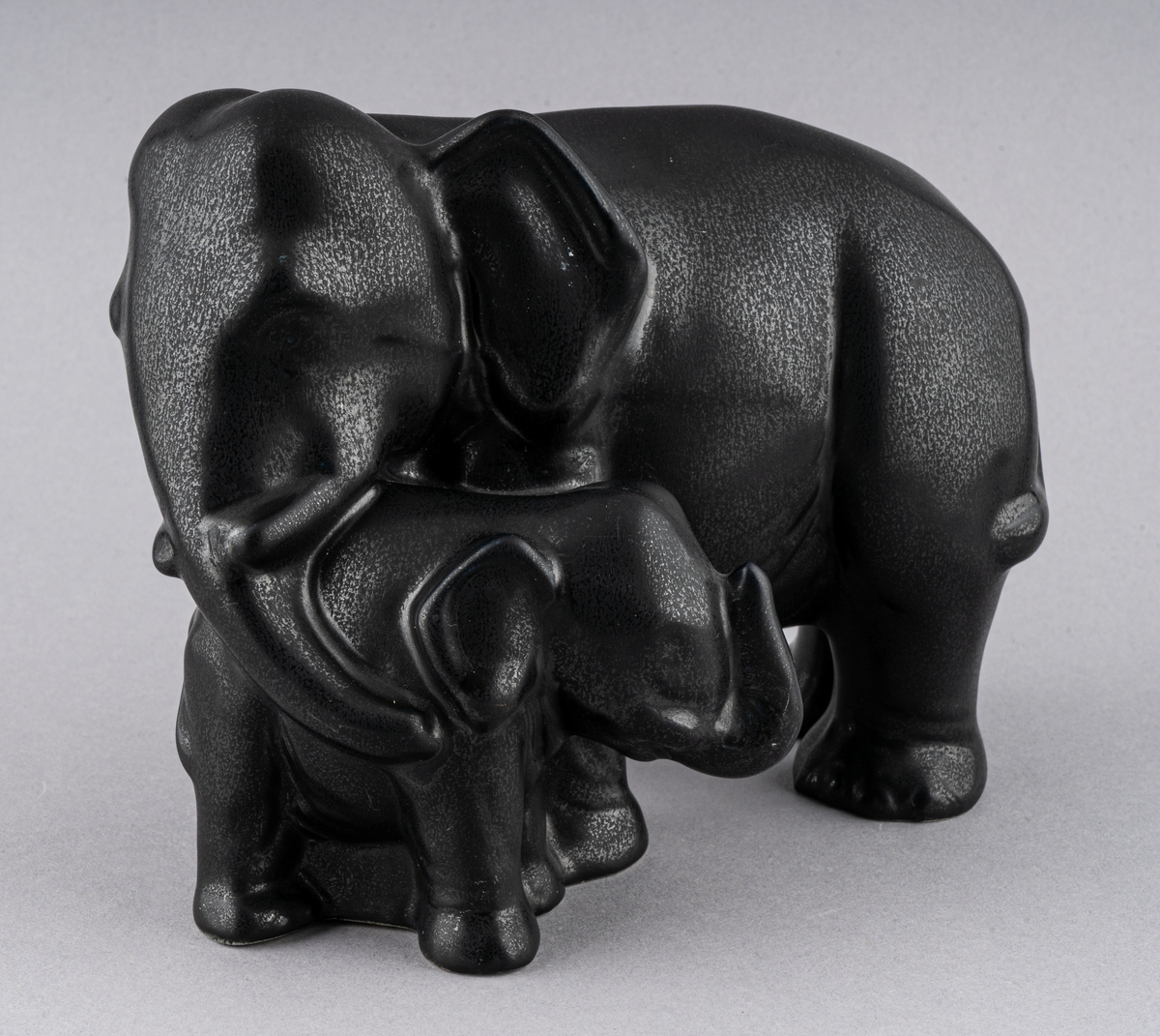 Figurin av flintgods formgiven av Dorothy Clough för Gefle Porslin 1956. Glasyr Mangania. En elefant med sin kalv.
