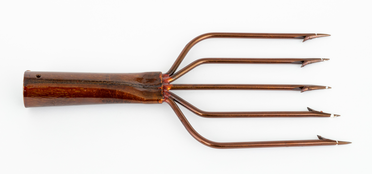 Lystergaffel uten skaft som er fabrikkprodusert av firmaet Mustad.  Det har 5 tinder av ståltråd som greiner seg ut, slik at avstanden mellom de ytterste spissene er cirka 11 centimeter. Spissene har cirka 4 millimeter lange tilsmidde mothaker. Videre er tindene sveiset fast til en skaftholk (fal) av ukjent metall (antatt aluminium). Skatholken (falen) er formet som en et  rør med et gjennombutt hull for en spiker eller skrue i den øvre enden. Lysteret kan festes til et skaft med en spiker eller skrue gjennom dette hullet. I den andre enden, der tindene er sveiset fast, er skaftholken sammenpresset til et rektangulært tverrsnitt. Lysergaffelen er påført en bronsefarget lakk,  og det antas at den er elektrokjemisk behandlet  for å være mer motstandsdyktig mot korrosjon og annen slitasje.
