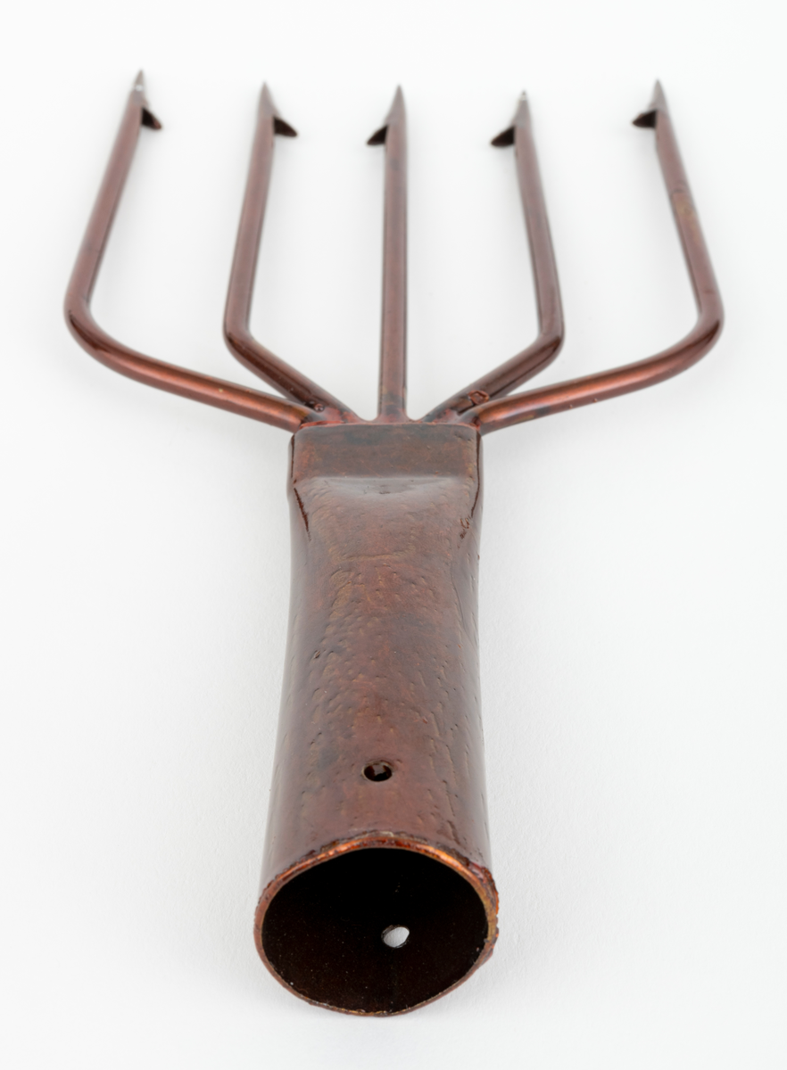 Lystergaffel uten skaft som er fabrikkprodusert av firmaet Mustad.  Det har 5 tinder av ståltråd som greiner seg ut, slik at avstanden mellom de ytterste spissene er cirka 11 centimeter. Spissene har cirka 4 millimeter lange tilsmidde mothaker. Videre er tindene sveiset fast til en skaftholk (fal) av ukjent metall (antatt aluminium). Skatholken (falen) er formet som en et  rør med et gjennombutt hull for en spiker eller skrue i den øvre enden. Lysteret kan festes til et skaft med en spiker eller skrue gjennom dette hullet. I den andre enden, der tindene er sveiset fast, er skaftholken sammenpresset til et rektangulært tverrsnitt. Lysergaffelen er påført en bronsefarget lakk,  og det antas at den er elektrokjemisk behandlet  for å være mer motstandsdyktig mot korrosjon og annen slitasje.
