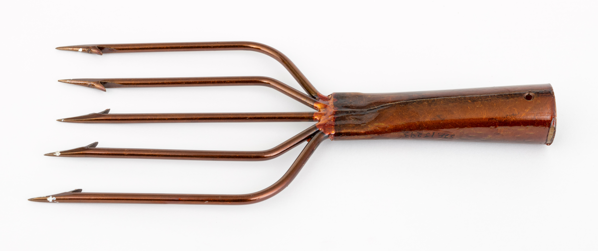 Lystergaffel uten skaft som er fabrikkprodusert av firmaet Mustad.  Det har 5 tinder av ståltråd som greiner seg ut, slik at avstanden mellom de ytterste spissene er cirka 11 centimeter. Spissene har cirka 4 millimeter lange tilsmidde mothaker. Videre er tindene sveiset fast til en skaftholk (fal) av ukjent metall (antatt aluminium). Skatholken (falen) er formet som en et  rør med et gjennombutt hull for en spiker eller skrue i den øvre enden. Lysteret kan festes til et skaft med en spiker eller skrue gjennom dette hullet. I den andre enden, der tindene er sveiset fast, er skaftholken sammenpresset til et rektangulært tverrsnitt. Lysergaffelen er påført en bronsefarget lakk,  og det antas at den er elektrokjemisk behandlet  for å være mer motstandsdyktig mot korrosjon og annen slitasje.
