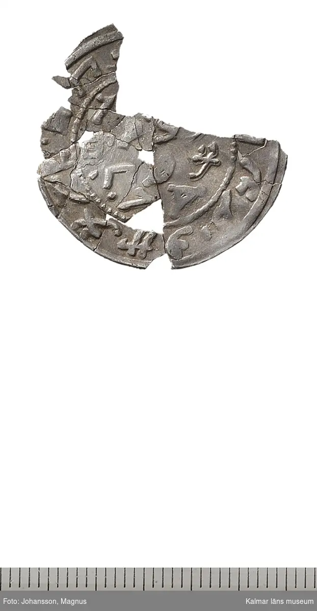 KLM 32774:462. Mynt. Mongolmynt? Silver. Fragmentariskt ungefär 3/4 dels mynt i många delar, delvis monterat ihoplimmat på Myntkabinettet.