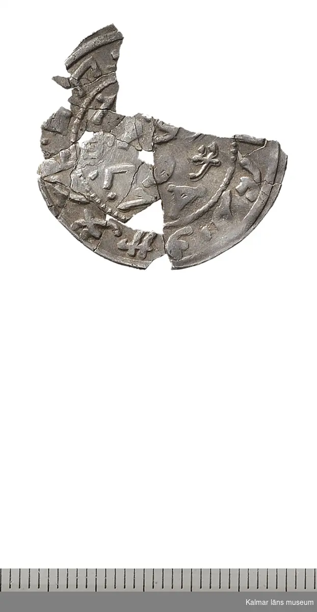 KLM 32774:462. Mynt. Mongolmynt? Silver. Fragmentariskt ungefär 3/4 dels mynt i många delar, delvis monterat ihoplimmat på Myntkabinettet.