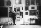 Vaktmästare Gustaf Lindqvist vakar myndigt över utställningarna vid Östergötlands museum. Fotoåret 1922 var även detsamma som museet flyttade in i den så kallade Hypoteksgården vid Platensgatan. De nya lokalernas rymd förbättrade avsevärt situationen för personalen, samlingarna och dess exponering. I stunden blickar Lindqvist ut över 1700-talsrummet.