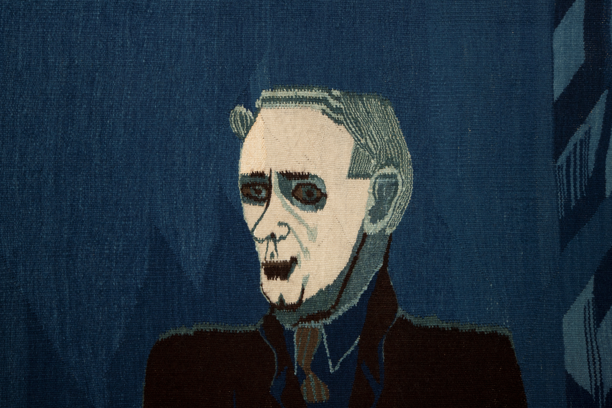 Figurativt og ornamentalt motiv vevd i hovedsakelig blått, mørkbrunt og hvitt (det brune og hvite er ufarget saueull, mens det blå er en rekke nyanser av potteblått, altså farget med planten indigo). Motivet er holdt i flaten med kun overlapping som uttrykk for romlighet. En stor, dresskledd mannsfigur er plassert i høyre del, og dominerer motivet. Han fyller nesten hele høyden, og er vendt mot (vår) venstre i trekvart profil; ansiktet er detaljert og svært lyst i kontrast til omgivelsene. Med sin venstre hånd holder han fast i en trekantform der kunstnerens signatur, verkets tittel og årstall, samt ordet 'NEI' to ganger er vevd inn. I sin høyre hånd holder han hånden til en liten, barbent, blå figur som opptrer nærmest kamuflert i bakgrunnen; denne støtter også sin andre hånd på mannsfigurens underarm. I motivets venstre del sees atten hoder ordnet i tre vertikale kolonner; den midre kolonnen er plassert bak eller inne i en geometrisk rankebord, mens den øverste og nederste figuren i høyre kolonne holder et langt sverd mellom seg. På sverdets håndtak står det 'NATO'. Bakgrunnen for figurene er blå, og i motivets høyre del, sammen med teksttrekanten, er det vevd en rekke asymmetriske ornamenter, også i blåtoner.