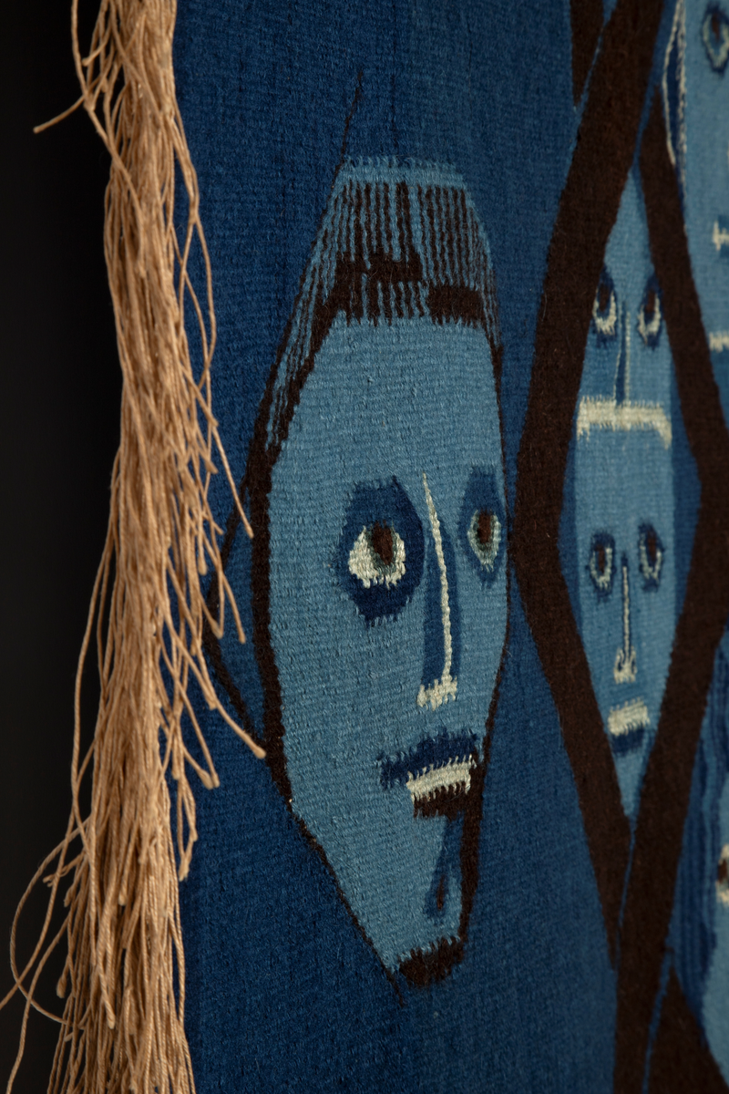 Figurativt og ornamentalt motiv vevd i hovedsakelig blått, mørkbrunt og hvitt (det brune og hvite er ufarget saueull, mens det blå er en rekke nyanser av potteblått, altså farget med planten indigo). Motivet er holdt i flaten med kun overlapping som uttrykk for romlighet. En stor, dresskledd mannsfigur er plassert i høyre del, og dominerer motivet. Han fyller nesten hele høyden, og er vendt mot (vår) venstre i trekvart profil; ansiktet er detaljert og svært lyst i kontrast til omgivelsene. Med sin venstre hånd holder han fast i en trekantform der kunstnerens signatur, verkets tittel og årstall, samt ordet 'NEI' to ganger er vevd inn. I sin høyre hånd holder han hånden til en liten, barbent, blå figur som opptrer nærmest kamuflert i bakgrunnen; denne støtter også sin andre hånd på mannsfigurens underarm. I motivets venstre del sees atten hoder ordnet i tre vertikale kolonner; den midre kolonnen er plassert bak eller inne i en geometrisk rankebord, mens den øverste og nederste figuren i høyre kolonne holder et langt sverd mellom seg. På sverdets håndtak står det 'NATO'. Bakgrunnen for figurene er blå, og i motivets høyre del, sammen med teksttrekanten, er det vevd en rekke asymmetriske ornamenter, også i blåtoner.