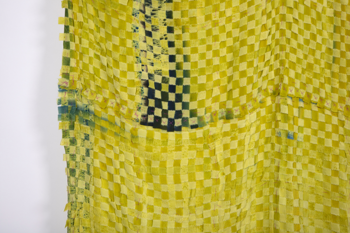 Rektangulært tekstil i flettet og malt silke. Tekstilet er satt sammen av to lengder flettede silkestrimler i 1,5cm bredde. Lengdene er festet sammen horisontalt. Tekstilet henger ned fra fem punkter, slik at det dannes fire buer øverst og avsluttes i buer nederst. Silkestrimlene er innfarget i forskjellige lysegrønne valører, enkelte steder er det malt på blågrønne felt som gir en skyggevirkning. Strimlene er revet i kantene.