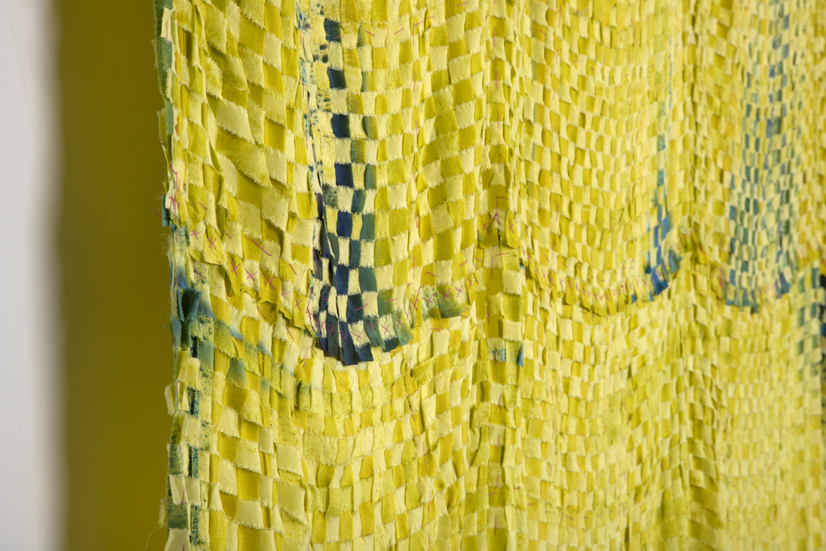 Rektangulært tekstil i flettet og malt silke. Tekstilet er satt sammen av to lengder flettede silkestrimler i 1,5cm bredde. Lengdene er festet sammen horisontalt. Tekstilet henger ned fra fem punkter, slik at det dannes fire buer øverst og avsluttes i buer nederst. Silkestrimlene er innfarget i forskjellige lysegrønne valører, enkelte steder er det malt på blågrønne felt som gir en skyggevirkning. Strimlene er revet i kantene.