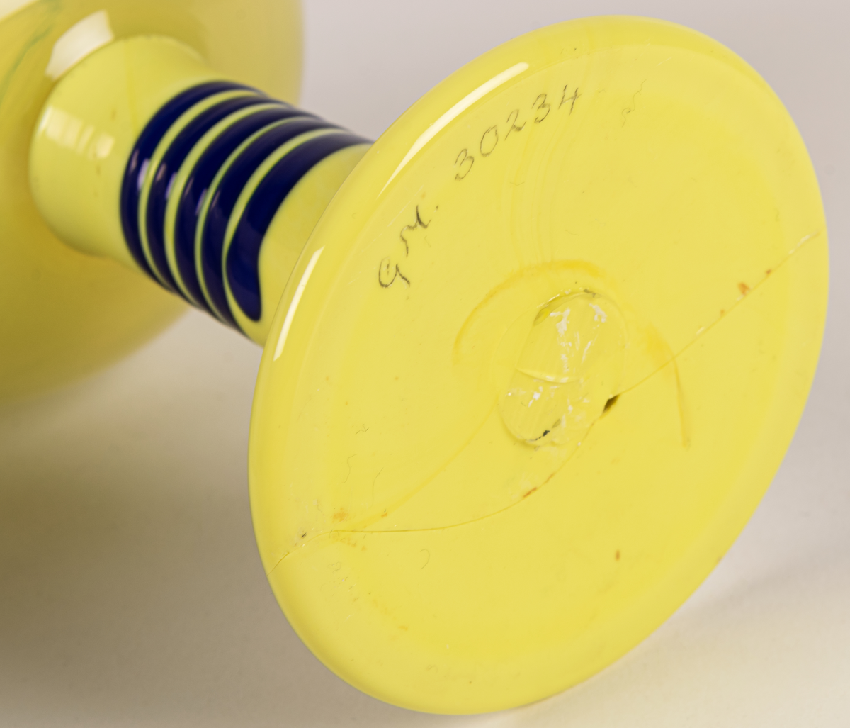 Popglas, gult med blåa ränder på foten.
