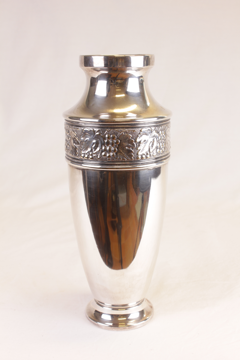 Blank vase med en bord av vinranker rundt skulderen.