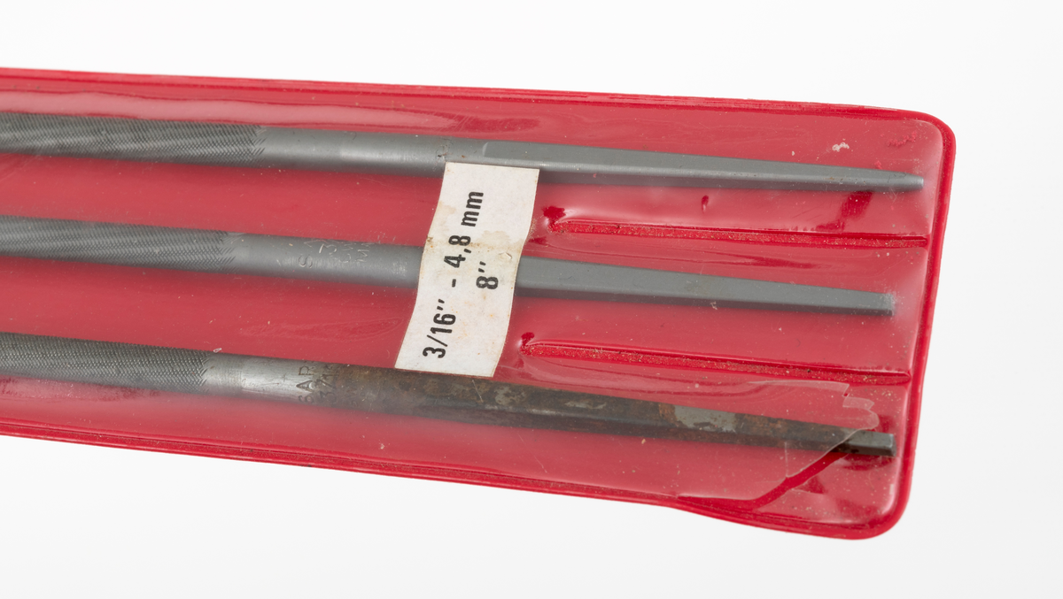 Tre filer, rundfiler, konstruert for kvessing av skjæretenner til skovltannkjeder på motorsager. Filene ligger en plastikkholder med rødt bakstykke og gjennomsiktig plast foran. Den gjennomsiktige plasten er inndelt i tre rom. Plastikkholderens bakstykke har varemerket Sarp påtrykt med hvite bokstaver øverst. Det er hull for oppheng av holderen. (Trolig for oppheng i butikkhylle.) To av filene i "pakka" er merket Sarp, mens den tredje er merket Stihl. Alle filene er 4,8 millimeter i diameter.  To av filene framstår som ubrukte, mens den tredje er tilnæremet ubrukt. 


[For mer informasjon om filing av sagkjeder, se skannet litteratur vedlagt under fanen "Referanser til filer".]