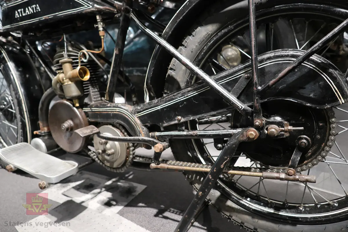 Atlanta. Motorsykkel, svart med hvit staffering. Motoren er en ensylindret bensindrevet forbrenningsmotor fra Villiers med et sylindervolum på 342 ccm (350) og en effekt på 8-12 hk. Albion 3-gir med clutch og kick starter. Sykkelen mangler noen deler. Atlanta med Villiers motor benevnes gjerne som Atlanta-Villiers. Merkingen CZ på veivhuset og Mark IXB på sylinder beviser at dette er en Villiers på 342 ccm fra perioden 1926-1929 (trolig org. motoren).