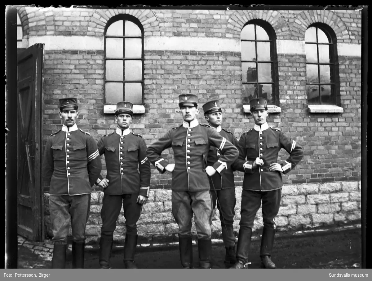 Gruppbild med fem kavallerister i uniform utanför kavallerikasernerna vid K1 i Stockholm.