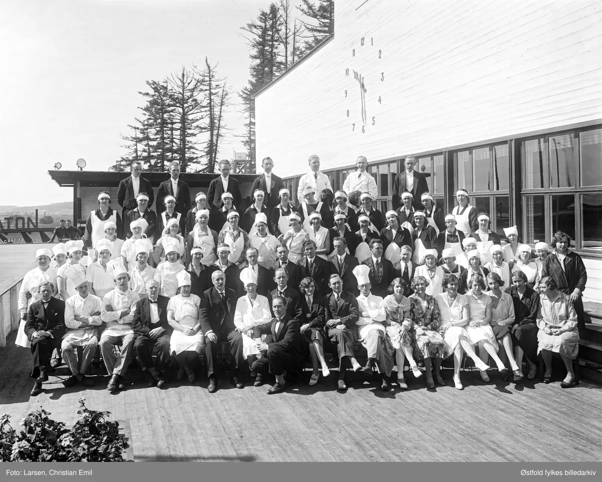 Østfoldutstillingen i Sarpsborg 1930. Personalet er oppstilt i en stor gruppe utenfor hovedrestauranten.
To linselus tll venstre i bildet.