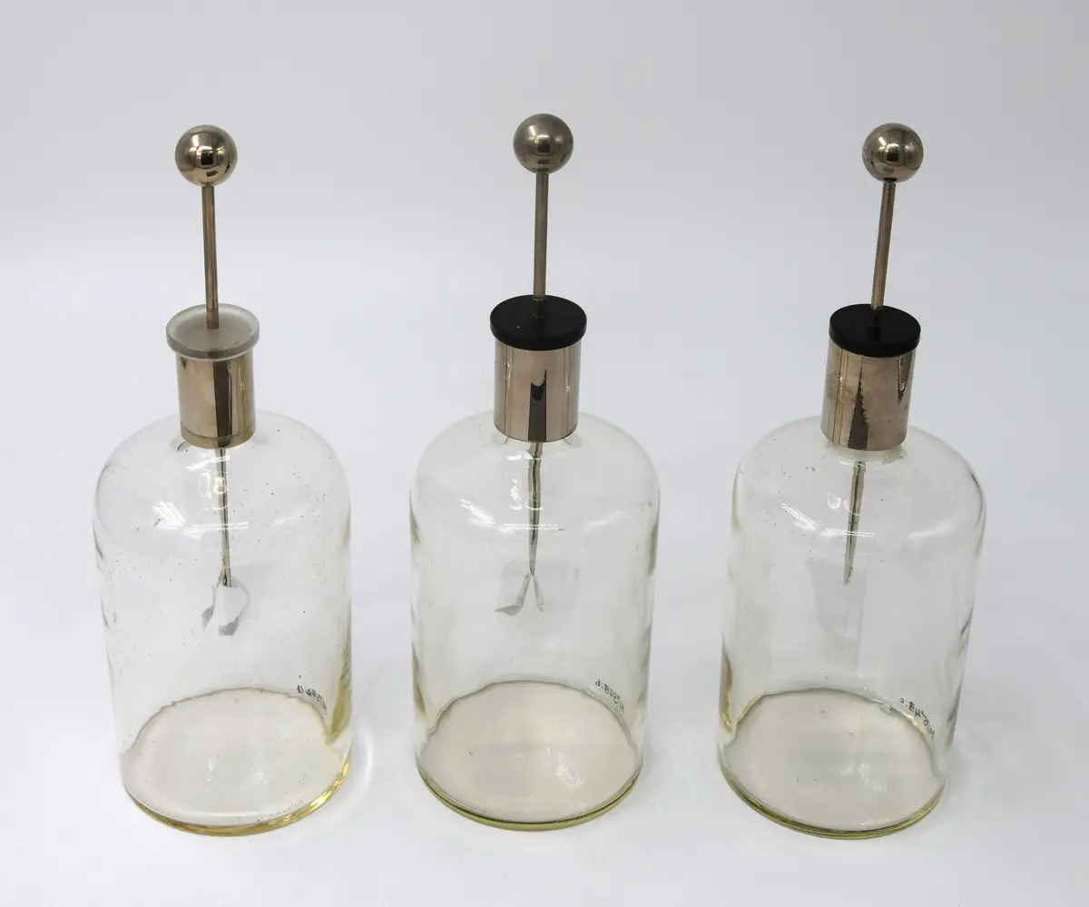 A) Bladelektroskop, glasflaska, höjd 18 cm, diam. 8,3 cm. Halsen har cylindrisk hylsa, av aluminium, höjd 3,5 cm. Propp av glas, genomborrad av en rundstav, i nedre änden tillplattad, med 2 st. tunna aluminiumblad, längd 3,5 cm, fästa i yttersta delen. Staven kröns av en kula, av aluminium, diam. 1,9 cm. Ena aluminiumbladet trasigt.

B) Bladelektroskop, glasflaska, höjd 17,5 cm, diam. 8,5 cm. Hals med cylindrisk hylsa, av aluminium, propp av hårdgummi, svart, genomborrad av rundstav, nedre änden tillplattad, med 2 st. aluminiumblad, krönt av kula, av aluminium, diam. 1,9 cm. 

C) Bladelektroskop, glasflaska, höjd 17,5 cm, diam. 8,5 cm. Hals med cylindrisk hylsa, av aluminium. Propp av hårdgummi, svart, genomborrad av aluminiumstav, tillplattad nedre ände, med 2 st. aluminiumblad, det ena trasigt. Krönt med kula, av aluminium, diam. 1,9 cm. 


Till kulan förs en laddad stav, strömmen leds genom rundstaven ner i bladen, vilka repellerar eftersom de laddats med samma slags elektricitet. 