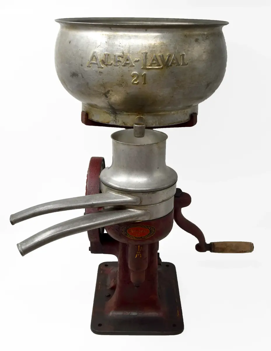 Separator Alfa-Laval 21 bestående av a) växelhus med vev och stativ b) mjölkbehållare, c-d) urtappningsanordning för mjölk och smörfett. 

a) växelhuset står på en rektangulär platta med hål för fyra fästeskruvar. Plattan övergår i en sockel med ovalt tvärsnitt i vars överdel infattats växelhus med kantkuggat hjul drivet av en handvev på motsatta sidan. Sockeln avslutats upptill i ett trearmat stativ. Samtliga delar av gjutjärn, rödlackerade. Tillverkarskylten av svart lackerad mässing placerad på sockelns nedre del under vevfästet. 

b) mjölkbehållaren 35 cm i diameter, höjd 18,9 cm. Den övre kanten något inåtböjd. Firmanamnet Alfa-Laval 21 i relief med 2 cm höga bokstäver. Under texten en avtappningskran med utsläppet i behållarens botten, placerat något på ena sidan. 

c) urtappningsanordning för mjölk består av en cylindrisk behållare 13,5 cm i diameter med spillrör 16,7 cm långt samt en flottör inne i cylidnern. 

d) urtappniningsanordning för grädde (mjölkfett) försedd med spillrör såsom föregående. En rund samlare med en tratt i mitten. Tratthållet 4,5 cm i diameter. 