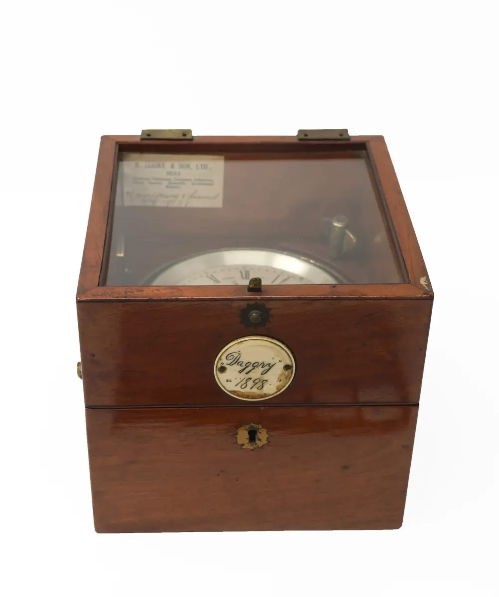 Skeppskronometer i låda av mahogny med tillhörande nyckel. Pappersetikett på insidan med följande text: "B. COOKE & SON, LTD., HULL. Nautical Opticians, Compass Adjusters, Chart Agents, Scientific Instrument Makers ".  På samma lapp, handskrivet: "Mainspring (?) & cleaned may 1937 ". 