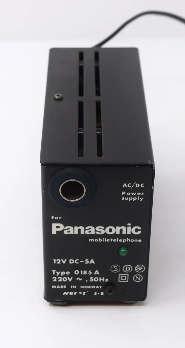 Mobiltelefon Panasonic med tillhörande nätaggregat (se M26070_B).