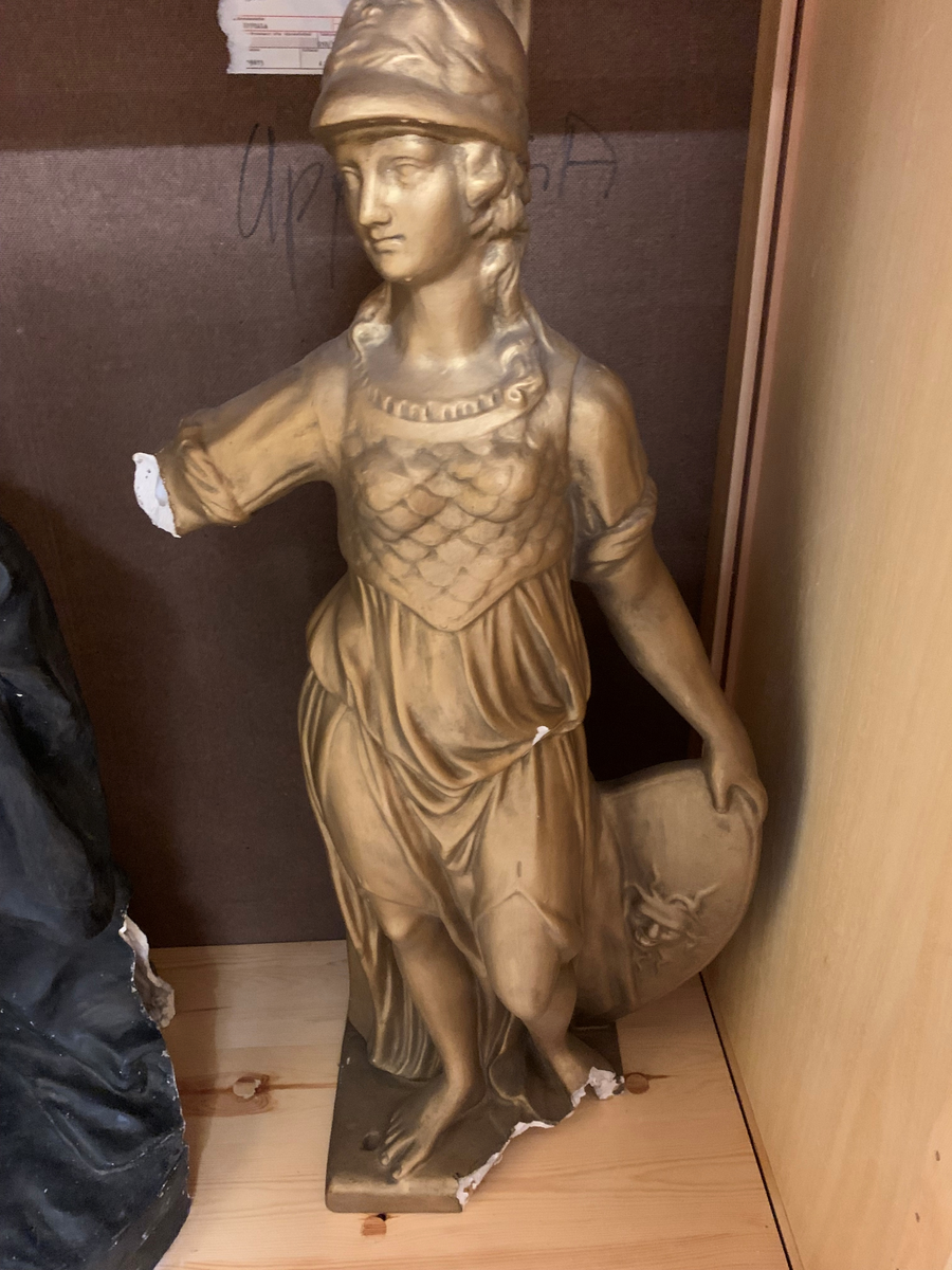 Staty föreställande Pallas Athena av förgylld gips.
Har stått på piedestal UM4247b.