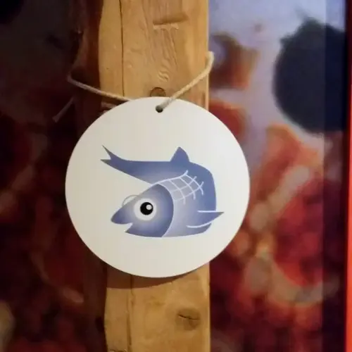 Vi ser et rundt skilt med maskoten Silja Sild på