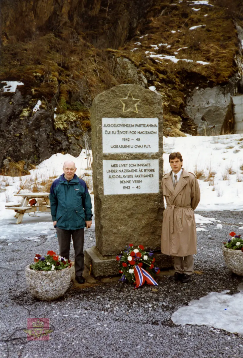 Vegdirektør Olav Søfteland og Torstein Rudihagen ved minnesteinen. 
Innskrift på steinen: 
Jugoslovenskim PARTIZANIMA 1942 - 45 Med livet som innsats under nazismens år bygde jugoslaviske partisane denne veien 1942-45.