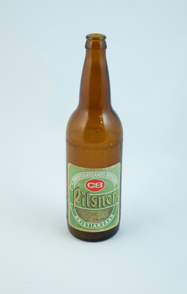 Brune glassflaskre med grønn papiretikett med hvit og lysebrun skrift. På den ene flasken er etiketten falmet hvit.